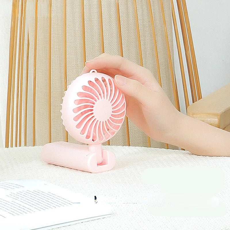 New foldable hand-held small fan Mini portable desktop fan Simple shape, strong wind speed, driven by two AA batteries - Stereotech
